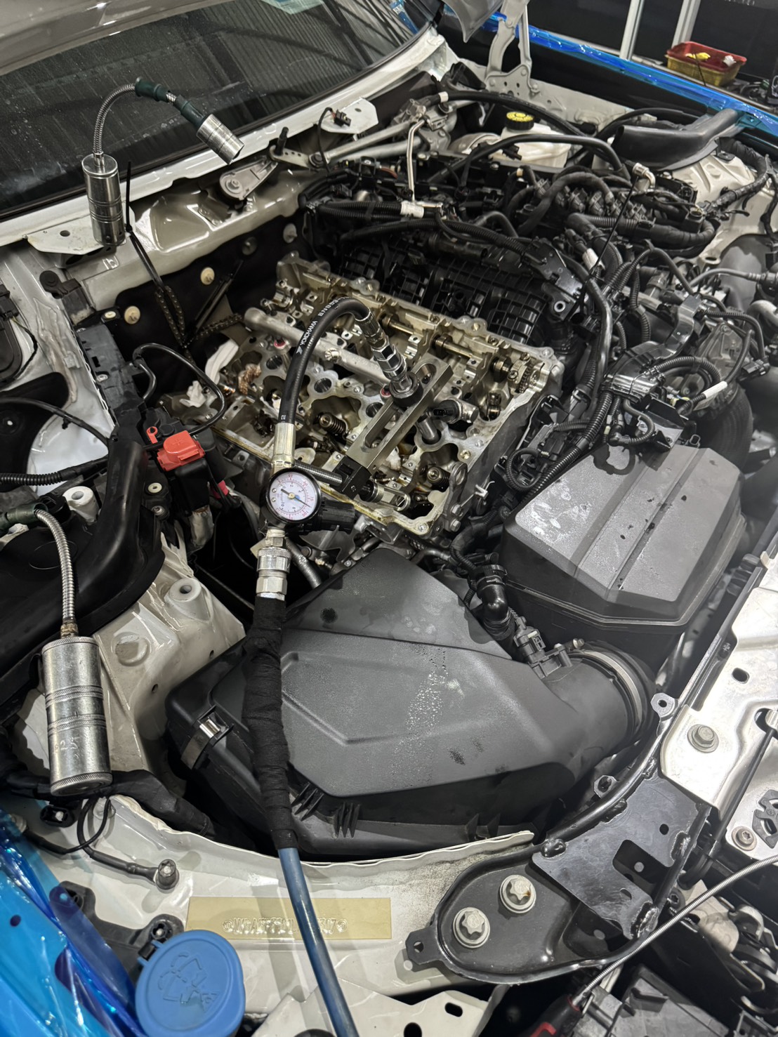 BMW B48 引擎汽門室蓋拆下後的汽缸頭狀態，壓縮壓力測試進行中