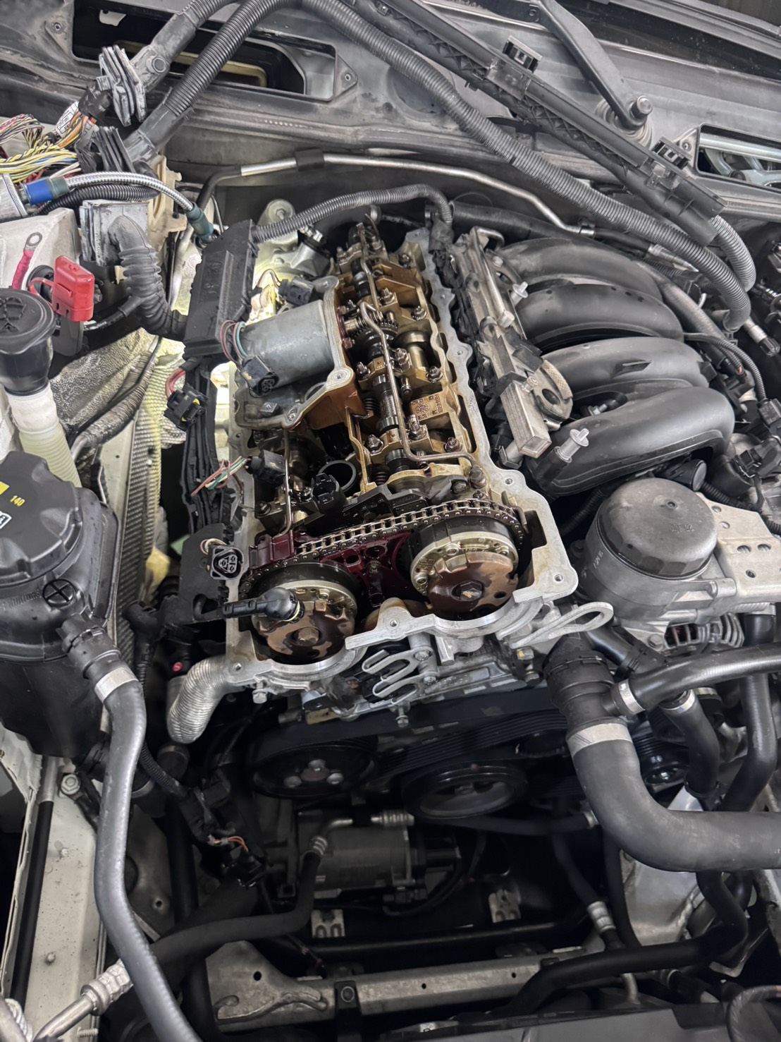 BMW X1 E84 N46N引擎艙維修前狀態，黑色塑膠汽門蓋可見｜聯承汽車台中